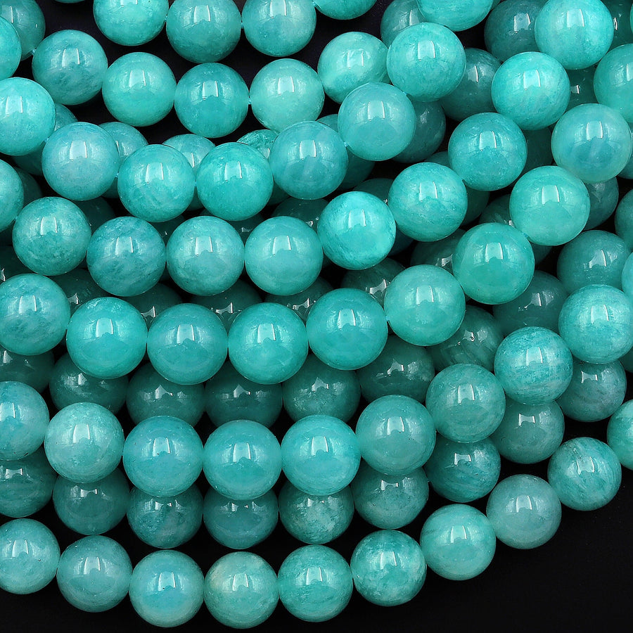 May include: Close-up view of numerous round, teal-colored beads.  The beads appear smooth and have a subtle, translucent quality. They are densely packed together, showcasing their uniform size and consistent color. The image highlights the beads' vibrant, light teal hue and their polished, glossy finish. These beads are ideal for jewelry making, crafting, and various decorative purposes. The consistent size and color suggest high-quality, uniform production.