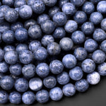 May include: A close-up image of a pile of round, blue and white speckled beads. The beads are smooth and have a natural, organic look.