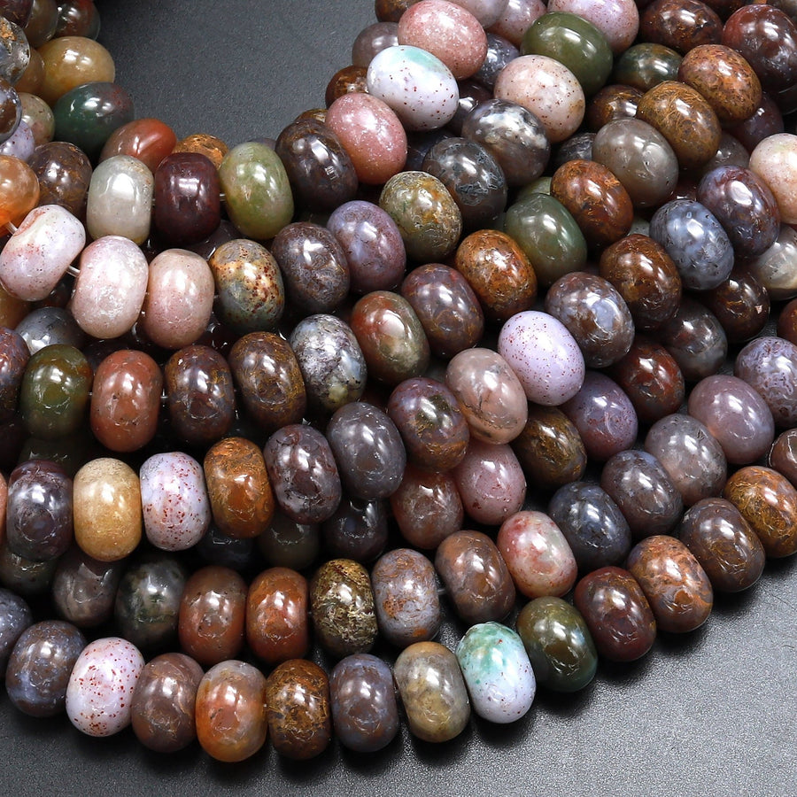 May include: A close-up of a strand of brown, green, and purple agate beads. The beads are round and have a smooth, polished finish. The beads are arranged in a random pattern, creating a visually appealing and unique look.