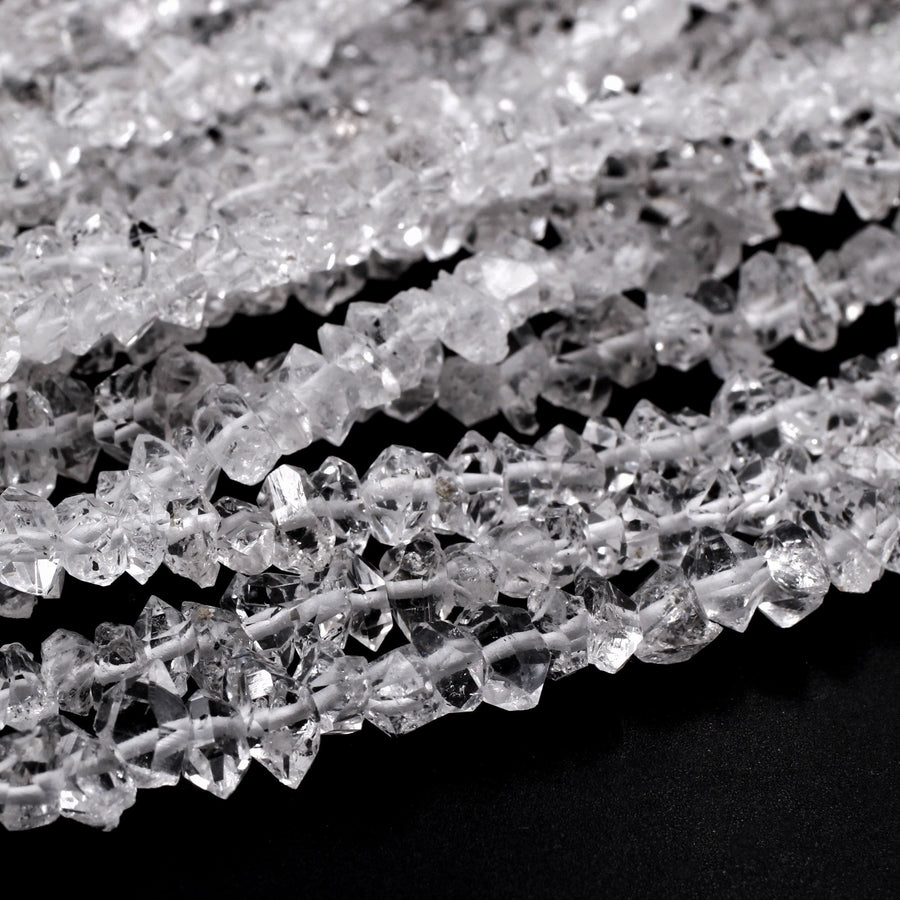 May include: A strand of clear quartz crystal beads. The beads are faceted and have a rough, natural look. The beads are strung on a white thread.