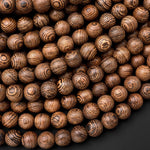 May include: A close-up image of a pile of brown wooden beads with a striped pattern. The beads are round and smooth, and they are arranged in a random pattern.