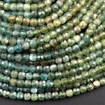 May include: A strand of green faceted gemstone beads. The beads are a light green color with a slightly darker green hue. The beads are all uniform in size and shape.