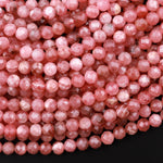 May include: A close-up image of a strand of pink, faceted gemstone beads. The beads are round and have a smooth, polished finish. The beads are arranged in a random pattern, creating a visually appealing texture.