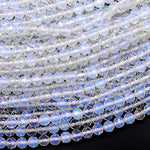 May include: A close-up of a strand of iridescent white faceted beads. The beads are round and have a smooth, polished finish. The beads are arranged in a circular pattern, creating a beautiful and intricate design.