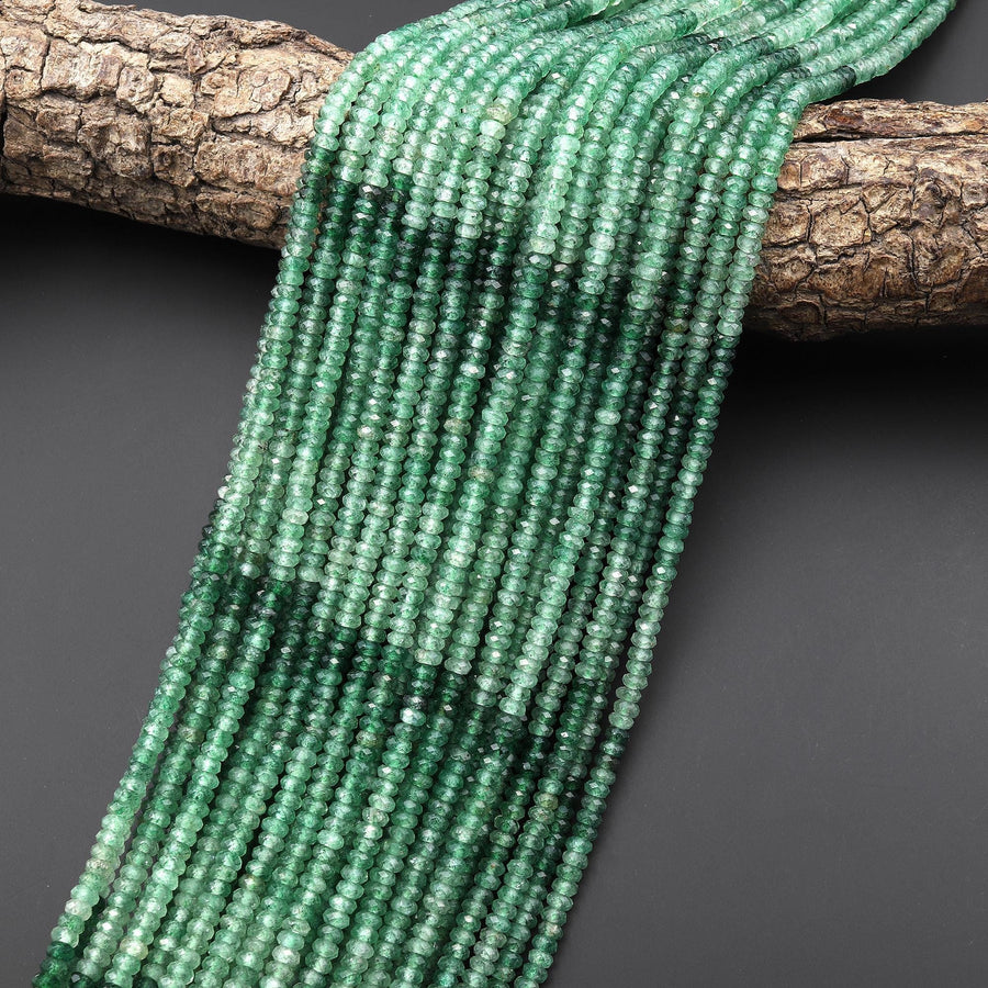 May include: A strand of green gemstone beads. The beads are faceted and have a slightly irregular shape. The beads are strung on a clear thread and are arranged in a long, flowing strand.