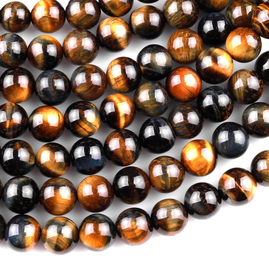 May include: A strand of round, smooth, polished tiger's eye beads in shades of brown, gold, and blue. The beads are arranged in a random pattern and are strung on a clear thread.