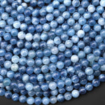 May include: A collection of round, blue aquamarine gemstone beads. The beads vary in shades of light and dark blue, with a polished, glossy finish. These beads are strung together, suggesting they are for jewelry making.